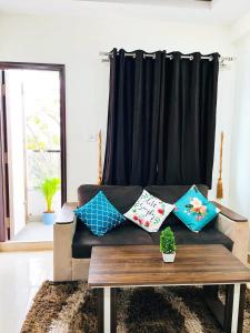 a living room with a couch with pillows on it at DivBnK homes Bangalore in Bangalore