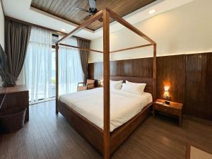 a bedroom with a canopy bed in a room at Bonheur at Karambunai in Kota Kinabalu
