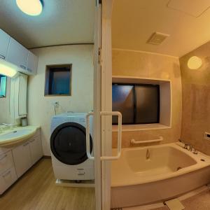ein Badezimmer mit einem TV und einer Badewanne in der Unterkunft TSURUOKA GINZA 朙 sukima in Tsuruoka