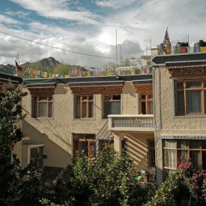 um grupo de edifícios com montanhas ao fundo em Hotel Lonchay Residency, Leh em Leh