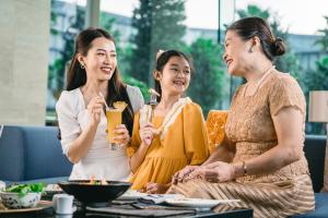 un grupo de tres mujeres sentadas alrededor de una mesa en JW Marriott Hotel Hanoi, en Hanói