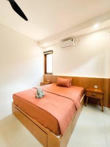 a bedroom with a large orange bed in a room at Villa Kamar Tamu Madurejo in Sleman