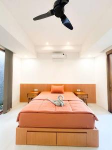 a bedroom with a bed with a ceiling fan at Villa Kamar Tamu Madurejo in Sleman