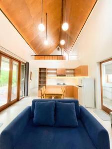 a living room with a blue couch and a table at Villa Kamar Tamu Madurejo in Sleman