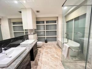 a bathroom with two sinks and a tub and a toilet at The Platinum Serviced Suites by Faced in Kuala Lumpur