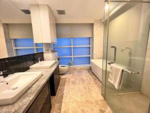 a bathroom with two sinks and a shower and a toilet at The Platinum Serviced Suites by Faced in Kuala Lumpur