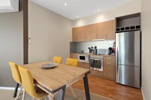 a kitchen with a wooden table and yellow chairs at Ocean View Penthouse in Cowes