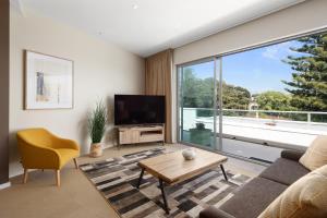 a living room with a couch and a large window at Ocean View Penthouse in Cowes