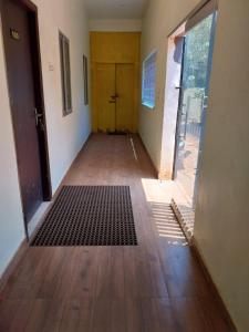 an empty hallway with a yellow door and a wooden floor at New greens inn in Yelagiri