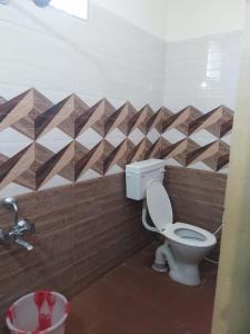 a bathroom with a toilet and a geometric wall at New greens inn in Yelagiri