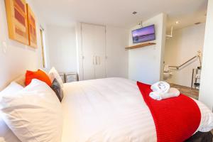 a bedroom with a large white bed with a red blanket at Powder 2A in Thredbo