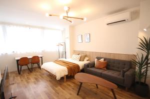 - une chambre avec un lit et un canapé dans l'établissement TOGOSHI 568 STAY Togoshi Ginza, à Tokyo