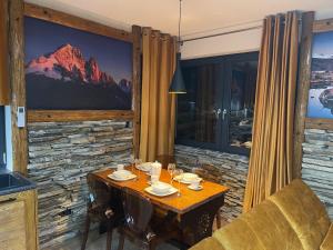 Un comedor con una mesa y un sofá. en APARTAMENT ALPY, en Szlachtowa