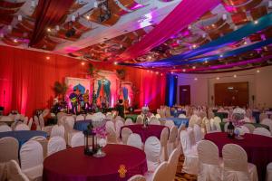 un salón de banquetes con sillas y mesas blancas y cortinas púrpuras en Parkcity Everly Hotel Bintulu, en Bintulu