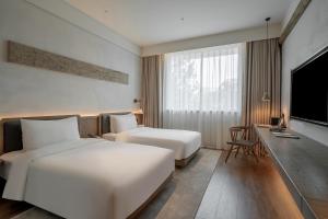 Postel nebo postele na pokoji v ubytování Sahe Hotel Shanghai World Expo