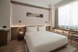 Postel nebo postele na pokoji v ubytování Sahe Hotel Shanghai World Expo