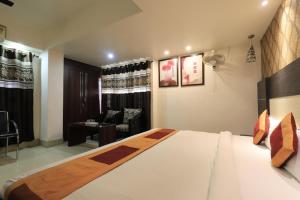 a bedroom with a large bed and a living room at Hotel Rashmi Guwahati in Guwahati