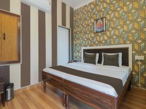 um quarto com uma cama grande e uma parede listrada em The Roxxy Royal Resort em Rishikesh