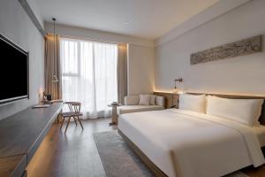 Postel nebo postele na pokoji v ubytování Sahe Hotel Shanghai World Expo