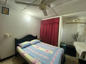 a bedroom with a bed and a red curtain at Casa Vecina Hostal in Santa Marta