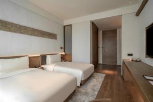 Postel nebo postele na pokoji v ubytování Sahe Hotel Shanghai World Expo