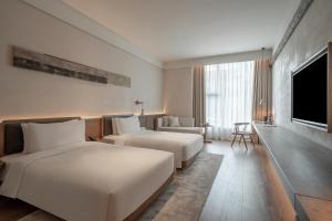 Postel nebo postele na pokoji v ubytování Sahe Hotel Shanghai World Expo