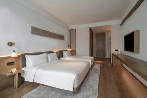 Postel nebo postele na pokoji v ubytování Sahe Hotel Shanghai World Expo
