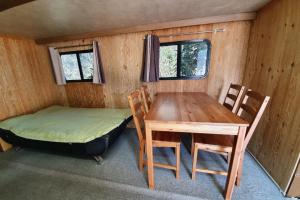 Byeonsan Auto Camping في بوان: غرفة بطاولة وسرير وطاولة وكراسي
