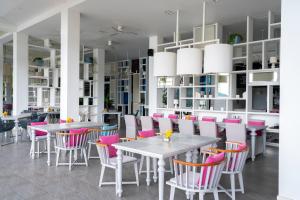 a dining room with tables and pink chairs at The Nai Harn in Nai Harn Beach