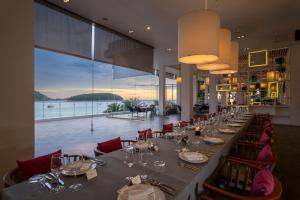 a long dining room with a long table and chairs at The Nai Harn - SHA Extra Plus in Nai Harn Beach