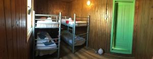 a room with three bunk beds and a green door at Hostel Flamingo Costinesti in Costinesti