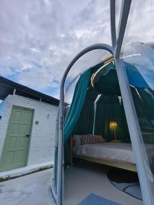 uma cama numa tenda cúpula numa varanda em The Starry Dome em Cameron Highlands