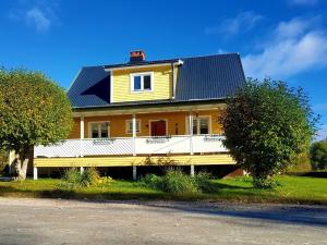 Gemütliches Ferienhaus in der Wildnis Lapplands في Blattniksele: منزل أصفر كبير بسقف أسود
