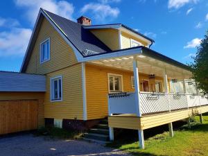 Gemütliches Ferienhaus in der Wildnis Lapplands في Blattniksele: منزل اصفر بسقف مقامر
