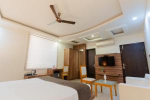 a bedroom with a bed and a table and a tv at Hotel Signature Inn in Jaipur