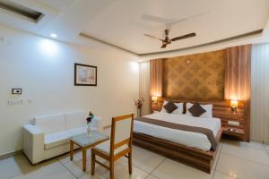 a bedroom with a bed and a couch and a table at Hotel Signature Inn in Jaipur