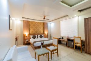 a hotel room with a bed and a desk at Hotel Signature Inn in Jaipur