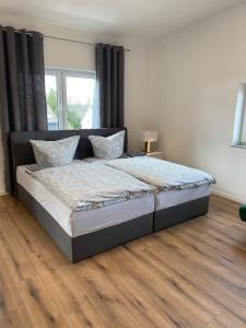 a large bed in a bedroom with a wooden floor at Bruchersee 4 oberbergisches Land in Marienheide