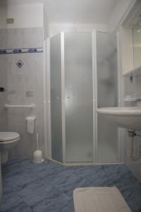a bathroom with a shower and a toilet and a sink at Hotel Cima Tosa in San Lorenzo in Banale
