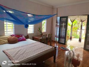 a bedroom with a bed with a blue canopy at Phonluer Angkor Homestay, in Siem Reap