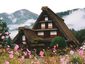 a house with a thatched roof in a field of flowers at Nagomiya Hirugano in Gujo +68 photos