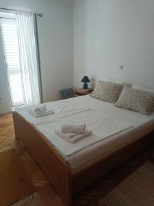 a bedroom with a large bed with two towels on it at Promajna apartman in Promajna
