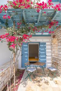 a patio with two chairs and a table with pink flowers at Aliki Maisonette by the beach in Aliki