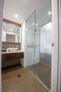 y baño con ducha acristalada y lavamanos. en Serenity Neptuna - 3brm luxury at Darwin Waterfront, en Darwin