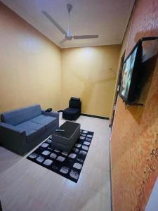 a living room with a couch and a flat screen tv at Peacefully Resort in Dodoma