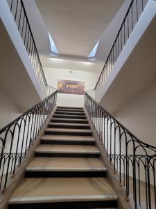 a staircase in a building with a painting on the wall at HOTEL KYRIAD ORANGE Centre Ville - A7-A9 - 3 Etoiles - HOTEL DES PRINCES - Provence Alpes Côte d'Azur - France in Orange