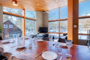 a dining room with a table with glasses on it at Hakuba Jade Chalet by Jade Group in Hakuba