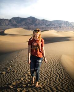 Eine Frau, die durch die Wüste geht. in der Unterkunft Royal Adventure Camp & Resort in Jaisalmer