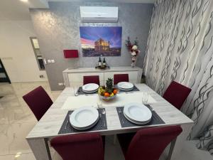 une salle à manger avec une table et des chaises rouges dans l'établissement Marsascala Sea View 2 Bed Apartment close to center! HPI 9934, à Marsaskala
