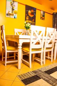 a dining room with a white table and chairs at S & A APARTMENTS in Thika